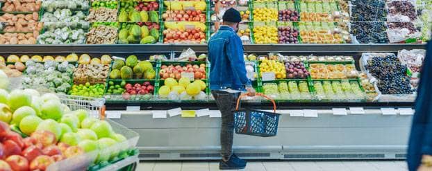 Foto man in de supermarkt die groenten uitzoekt