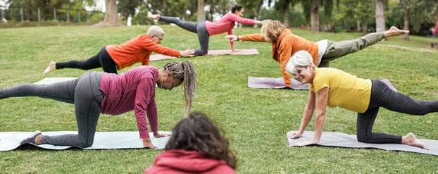 Foto: groep vrouwen doen yoga-oefeningen in het park