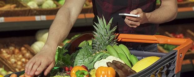 Een man die op een mobiel kijkt in een omgeving van gezonde voeding