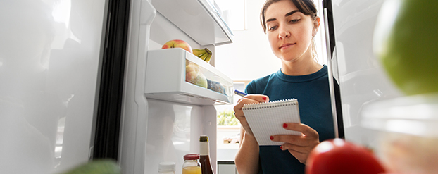 Vrouw maat zich gereed voor de Nationale Suiker Challenge en controleert de koelkast