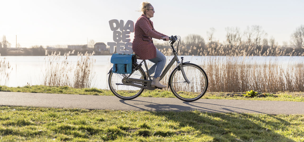 Foto van vrouw op de fiets met letters DIABETES achterop