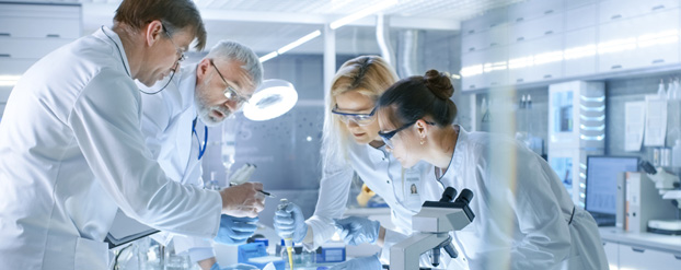 Wetenschappers in een laboratorium staan te werken bij een tafel