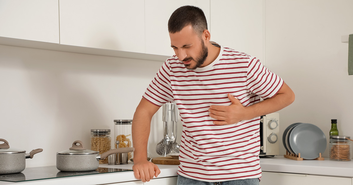 Man grijpt naar zijn hart in een keuken