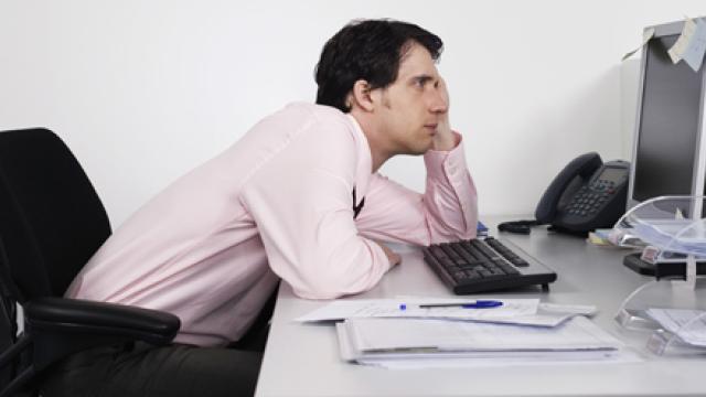 Man hangt voor de computer aan bureau