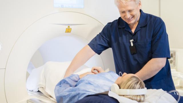 Onderzoeker helpt patiënt die in MRI-scanner gaat