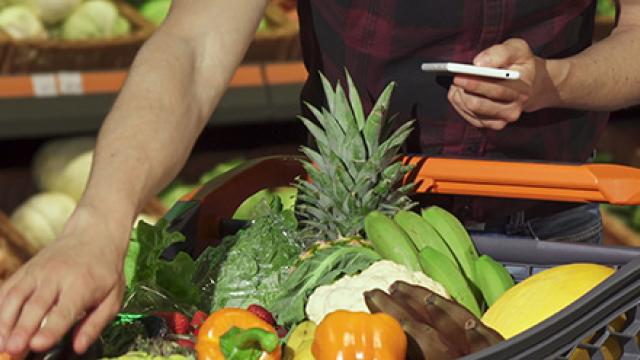 Een man die op een mobiel kijkt in een omgeving van gezonde voeding