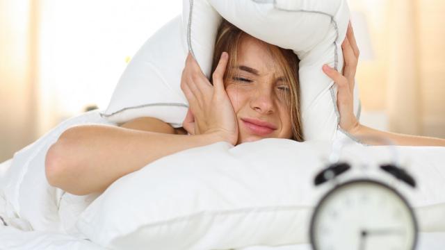 Foto: Vrouw met kussen over haar hoofd