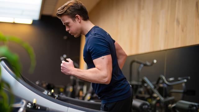 Man met sensor op zijn arm rent op de loopband
