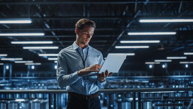 ICT-medewerker met laptop in groot datacenter