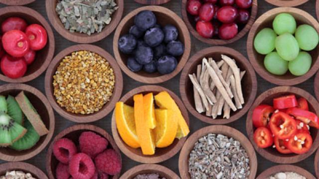 sinaasappel, druiven, pepertjes, kiwi's en andere producten in houten kommetjes