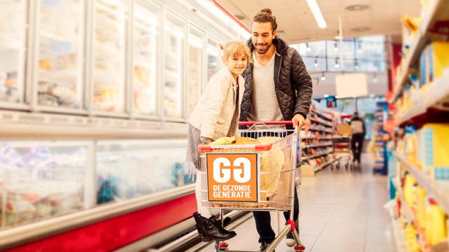 Man en kind in supermarkt met boodschappen-kar