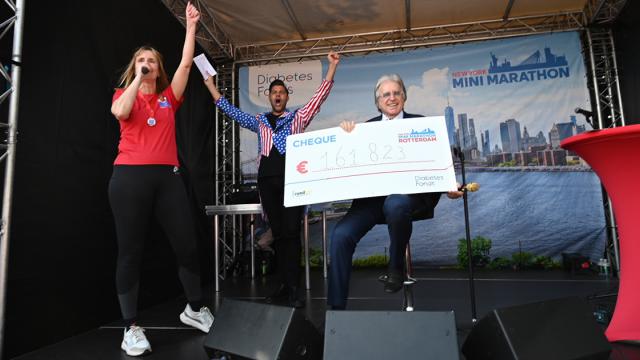 Foto Lee Towers met cheque van € 161.823, de opbrengst van de New York Minimarathon