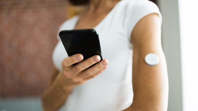 Vrouw test bloedglucosewaarde met ontinue bloedglucosemeter