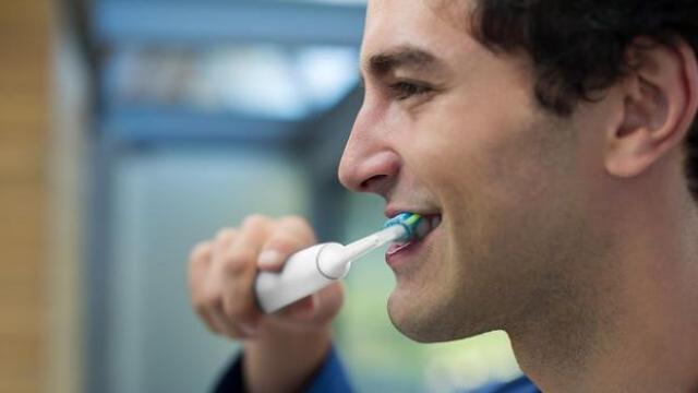 Mondzorg: jonge man poetst zijn tanden