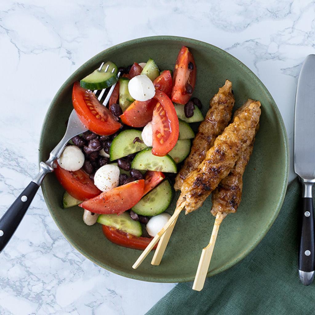 Drie kipspiesjes en salade van tomaten, komkommer, rode ui en bonen