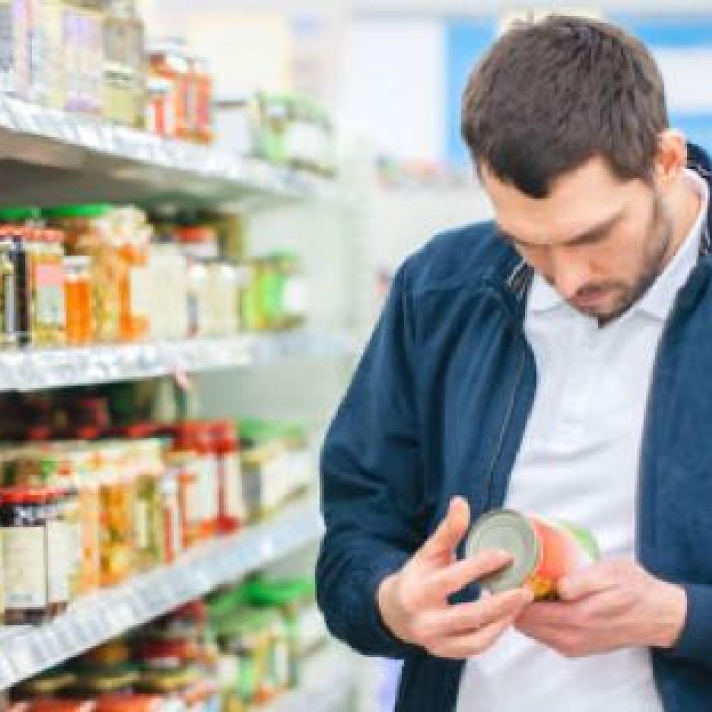 Foto van man die boodschappen doet en etiket goed leest