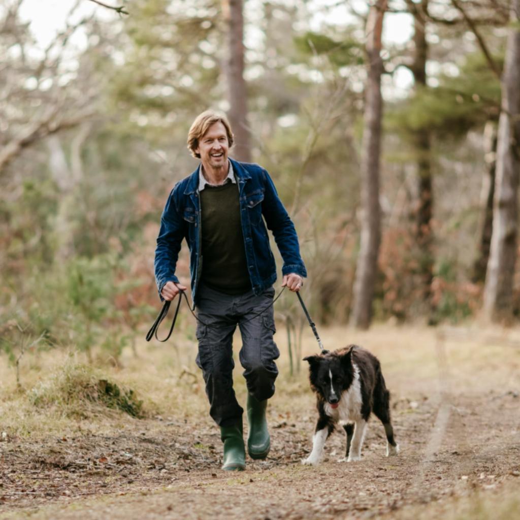 Man en hond wandelen in het bos