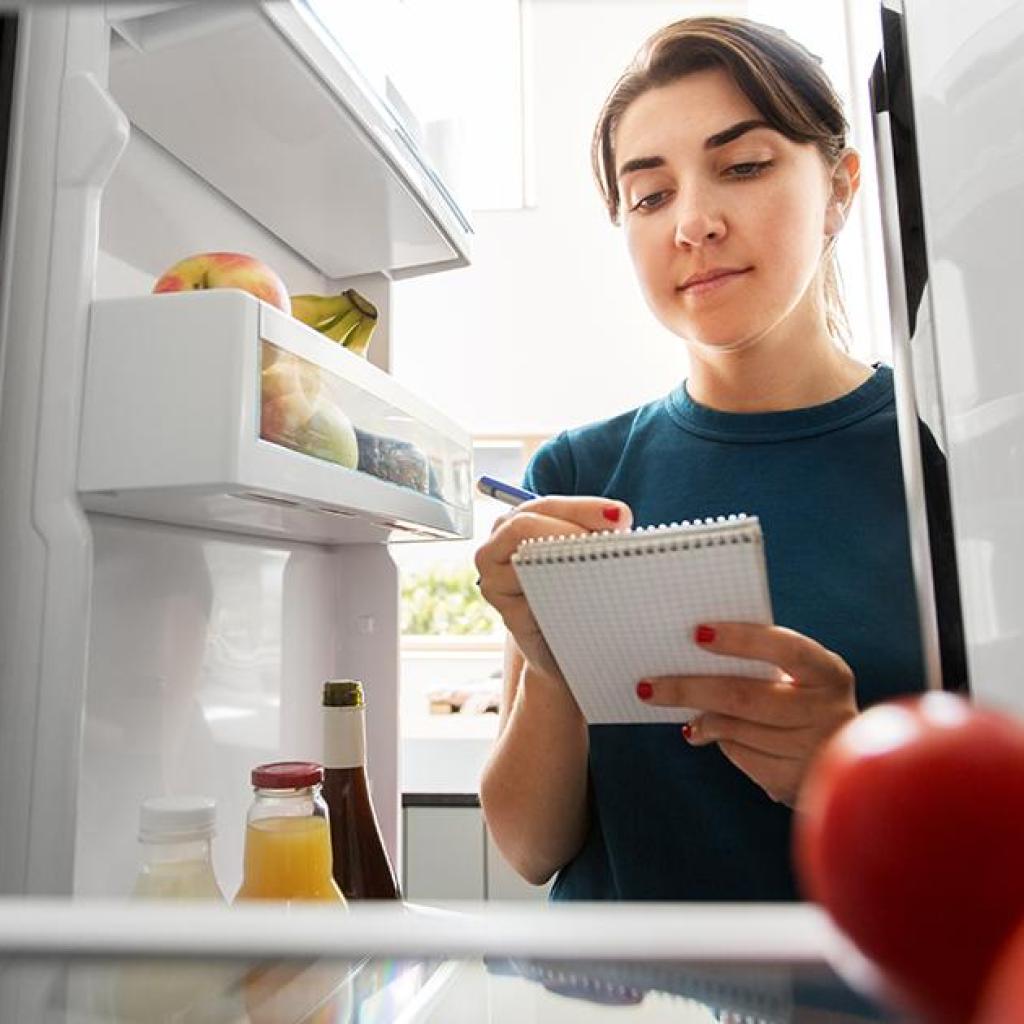 Vrouw checkt de koelkast op suiker