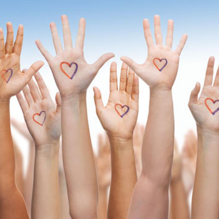 Verschillende handen met een rood-blauwe hart