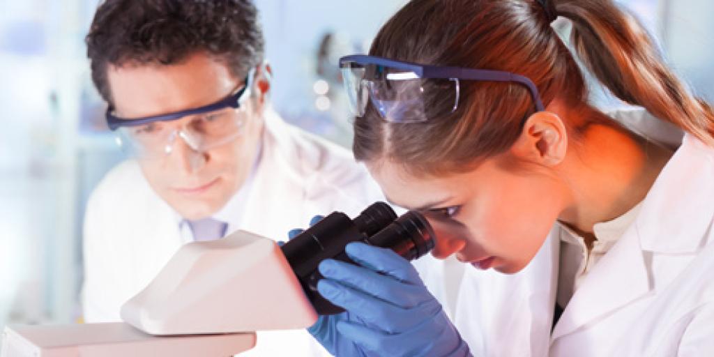 Onderzoekster kijkt door microscoop naar eiwitten