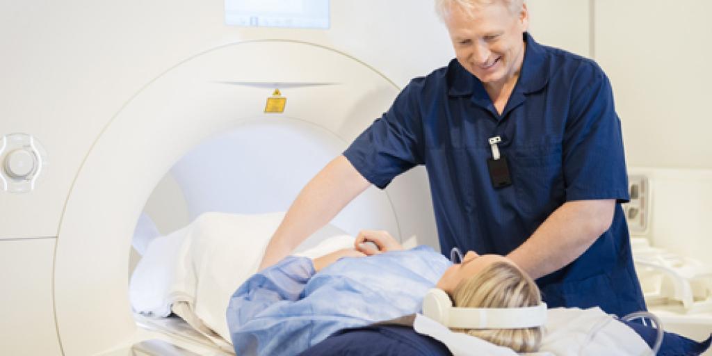 Onderzoeker helpt patiënt die in MRI-scanner gaat