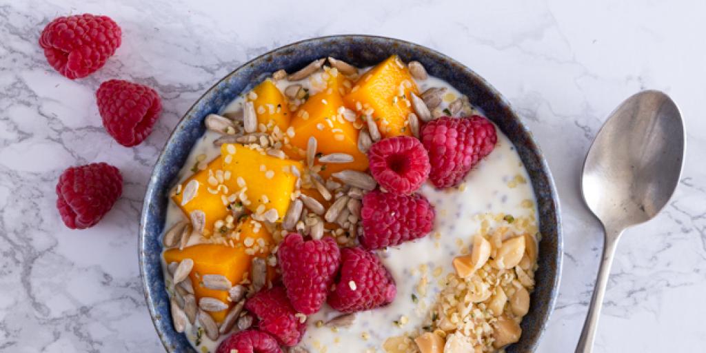 Chiapudding met mango, frambozen, macadamia, zonnebloempitten en hhennepzaad