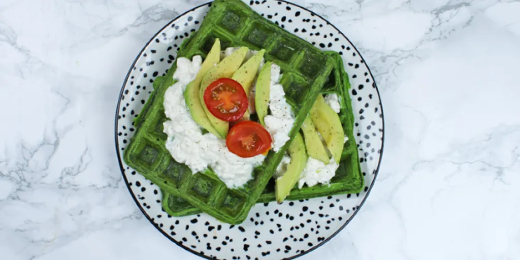 Foto van spinaziewafel met hüttenkäse, avocado en tomaatjes