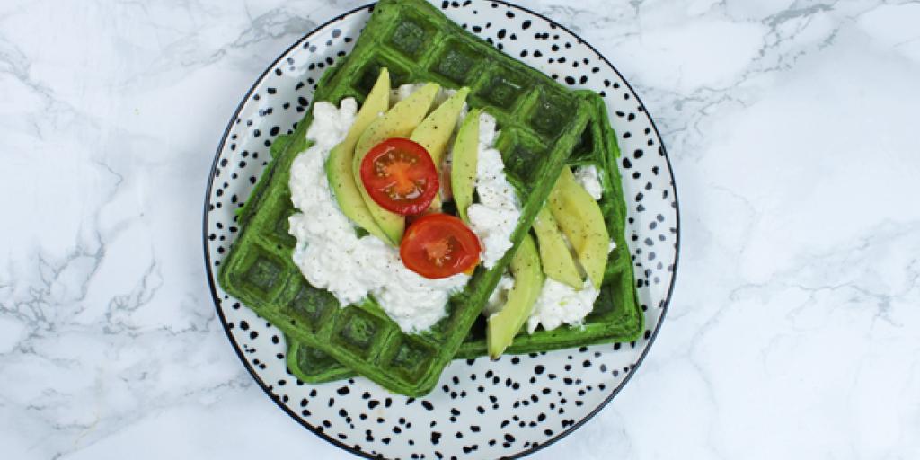 Foto van spinaziewafel met hüttenkäse, avocado en tomaatjes