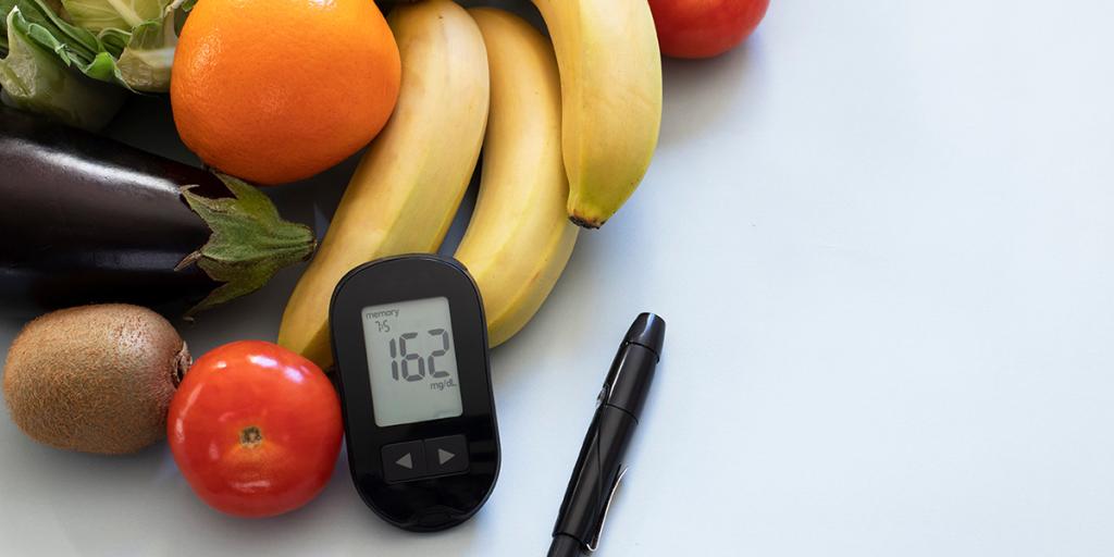 verschillende soorten groente  en fruit en een bloedglucosemeter