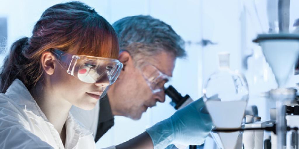 Onderzoekers met reageerbuizen en microscopen