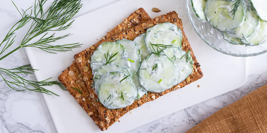 Komkommersalade met dille op een volkoren cracker
