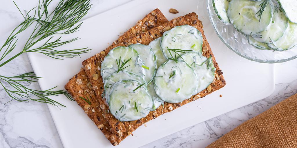 Komkommersalade met dille op een volkoren cracker