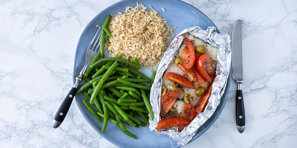 Een vispakketje met tomaten en olijven,  sperziebonen en zilvervliesrijst