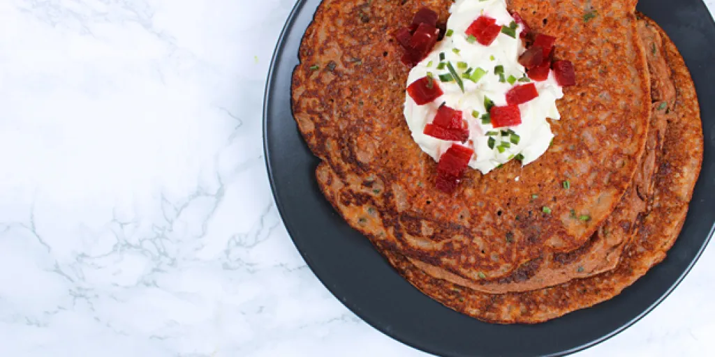 Foto rode bieten pannenkoeken  met nog wat bieslook en creme fraiche als topping