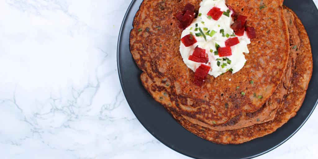 Foto rode bieten pannenkoeken  met nog wat bieslook en creme fraiche als topping