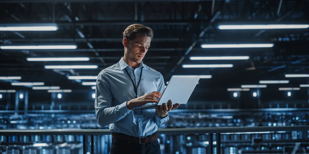 ICT-medewerker met laptop in groot datacenter