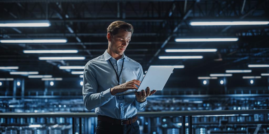 ICT-medewerker met laptop in groot datacenter