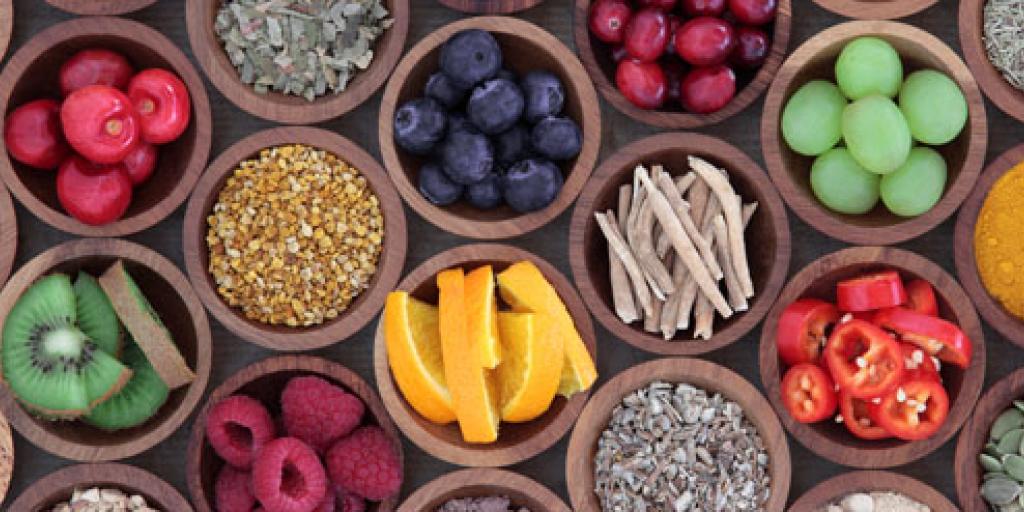 sinaasappel, druiven, pepertjes, kiwi's en andere producten in houten kommetjes