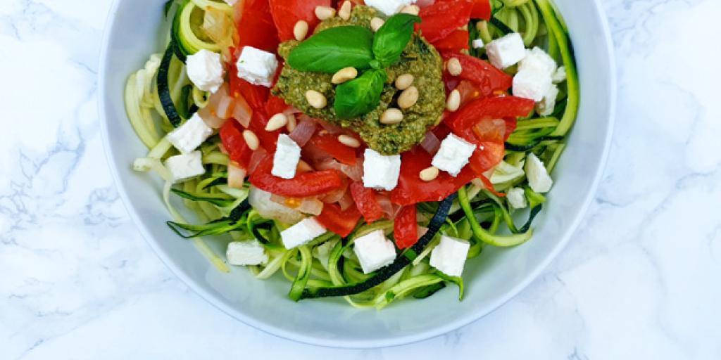 Courgette pasta met pesto en tomaatjes, pijnboompitten en feta