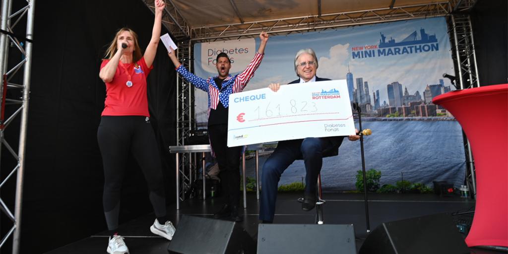 Foto Lee Towers met cheque van € 161.823, de opbrengst van de New York Minimarathon
