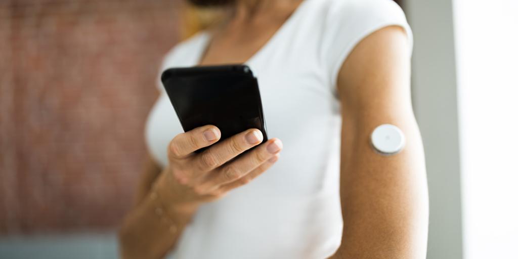 Vrouw test bloedglucosewaarde met ontinue bloedglucosemeter