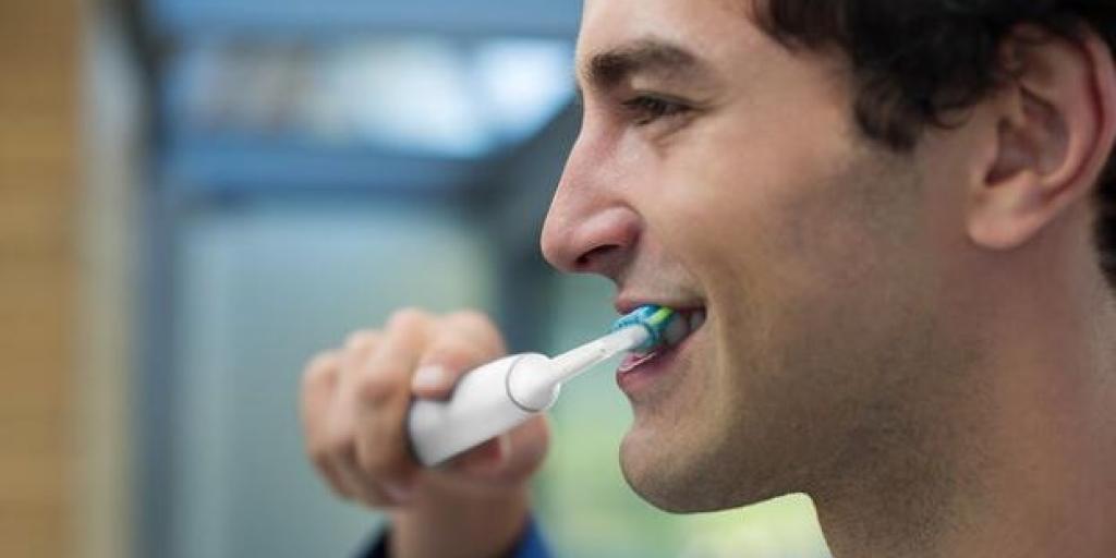 Mondzorg: jonge man poetst zijn tanden