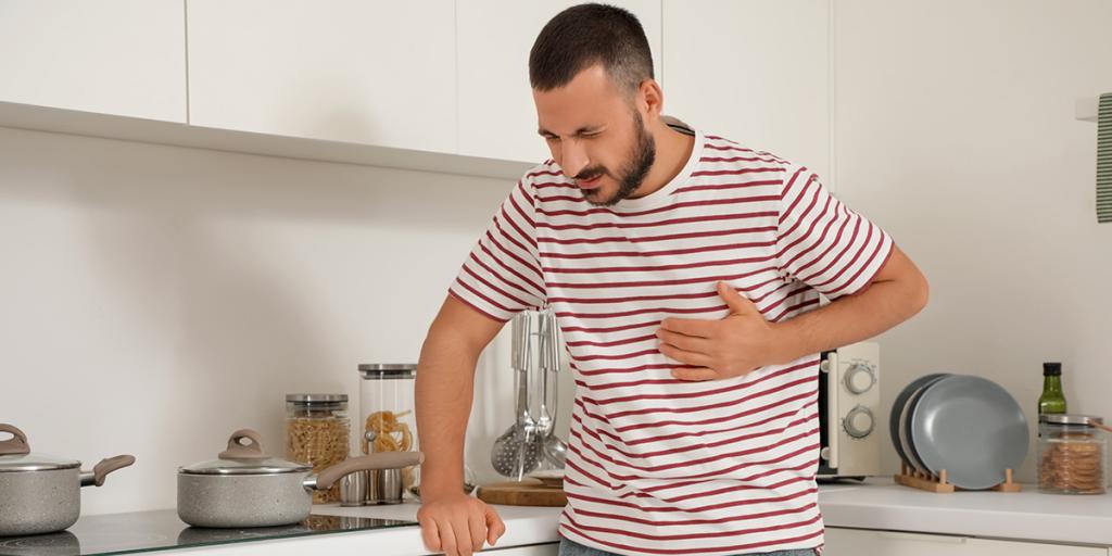 Man grijpt naar zijn hart in een keuken