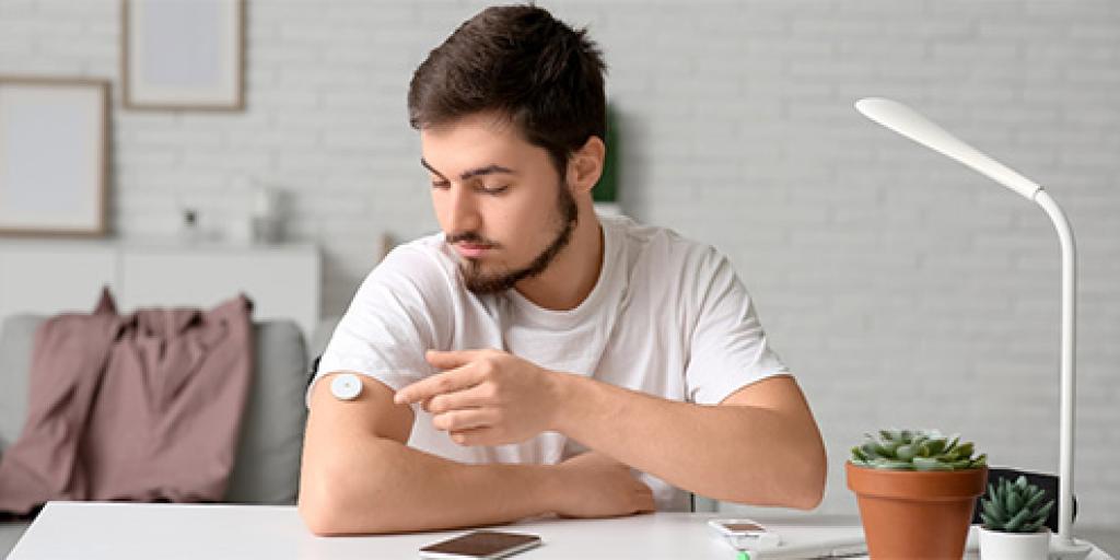Man bekijkt zijn bloedsuikermeter 