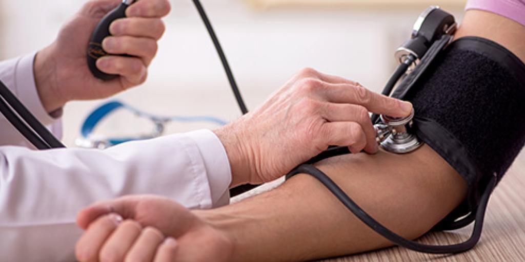 dokter meet bloeddruk op bij patient