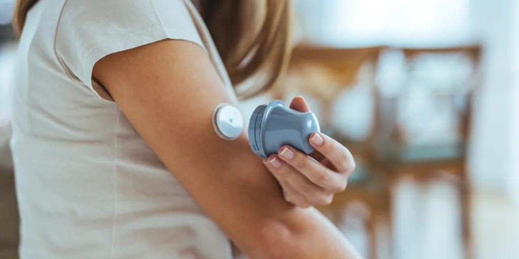 Vrouw plakt glucosesensor in