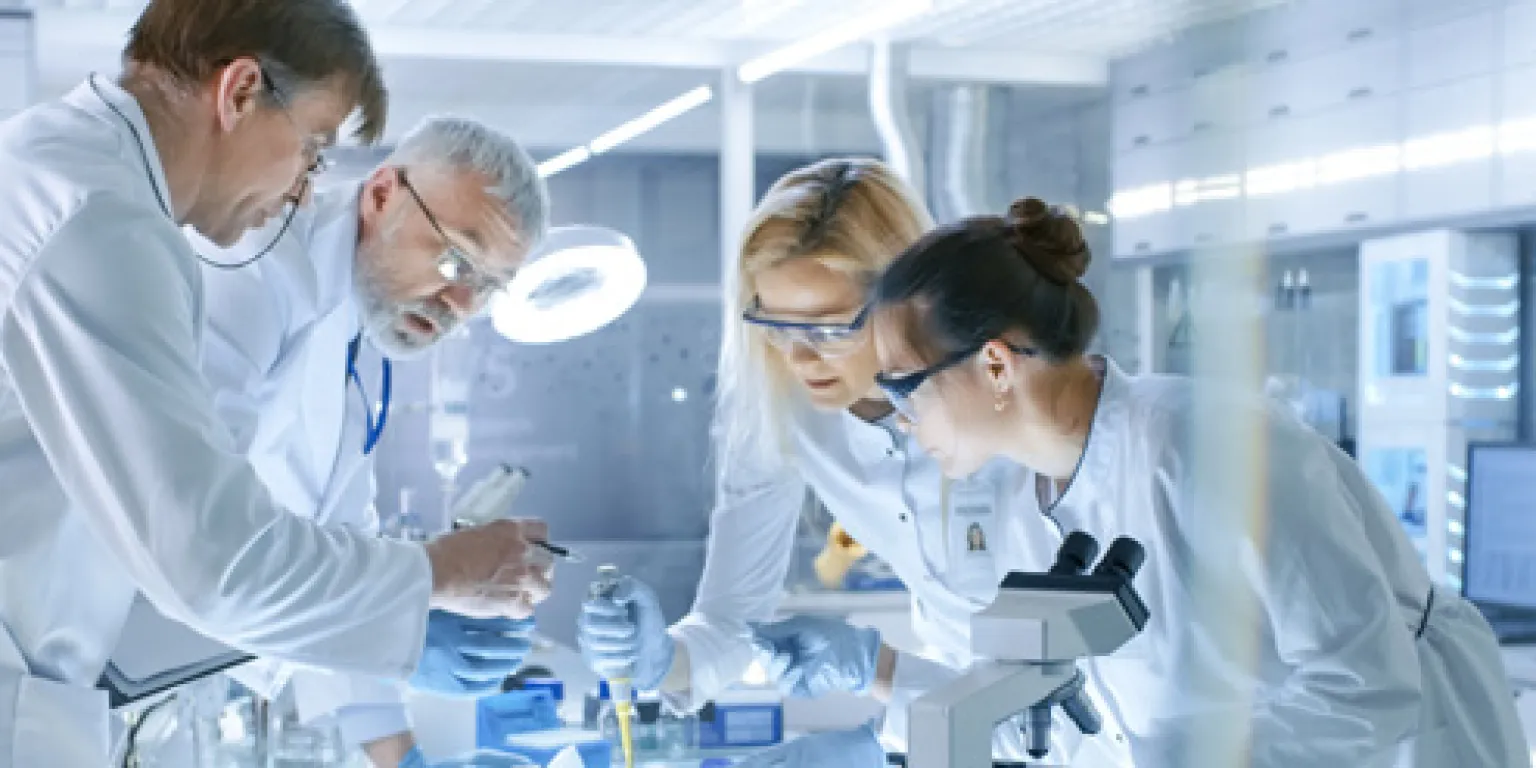 Wetenschappers in een laboratorium staan te werken bij een tafel
