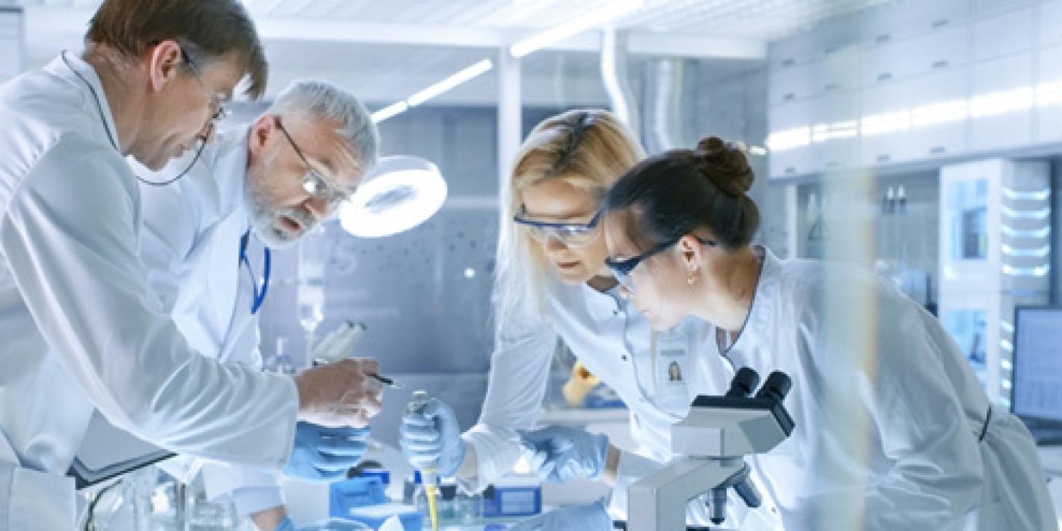 Wetenschappers in een laboratorium staan te werken bij een tafel