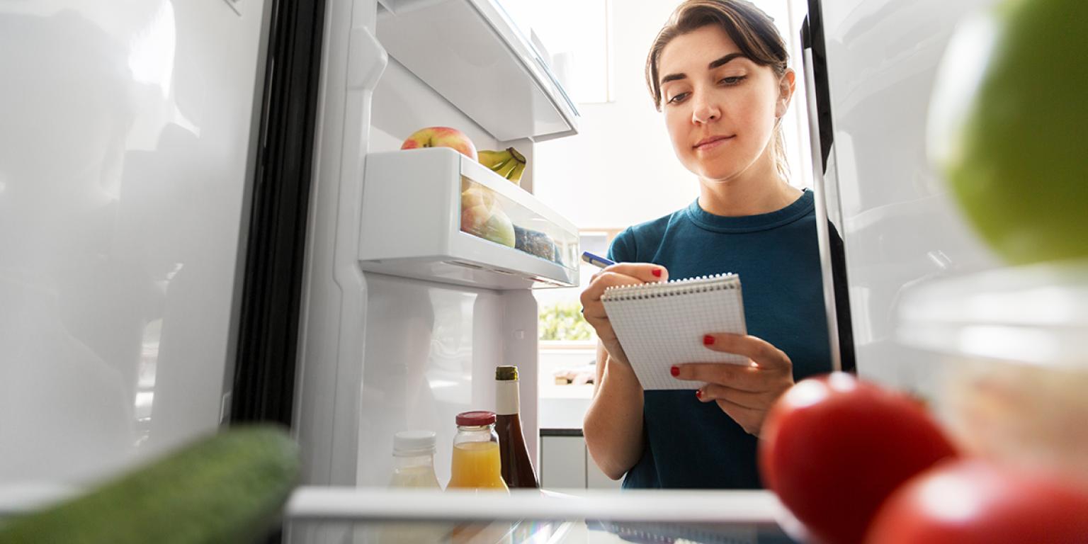 Vrouw maat zich gereed voor de Nationale Suiker Challenge en controleert de koelkast