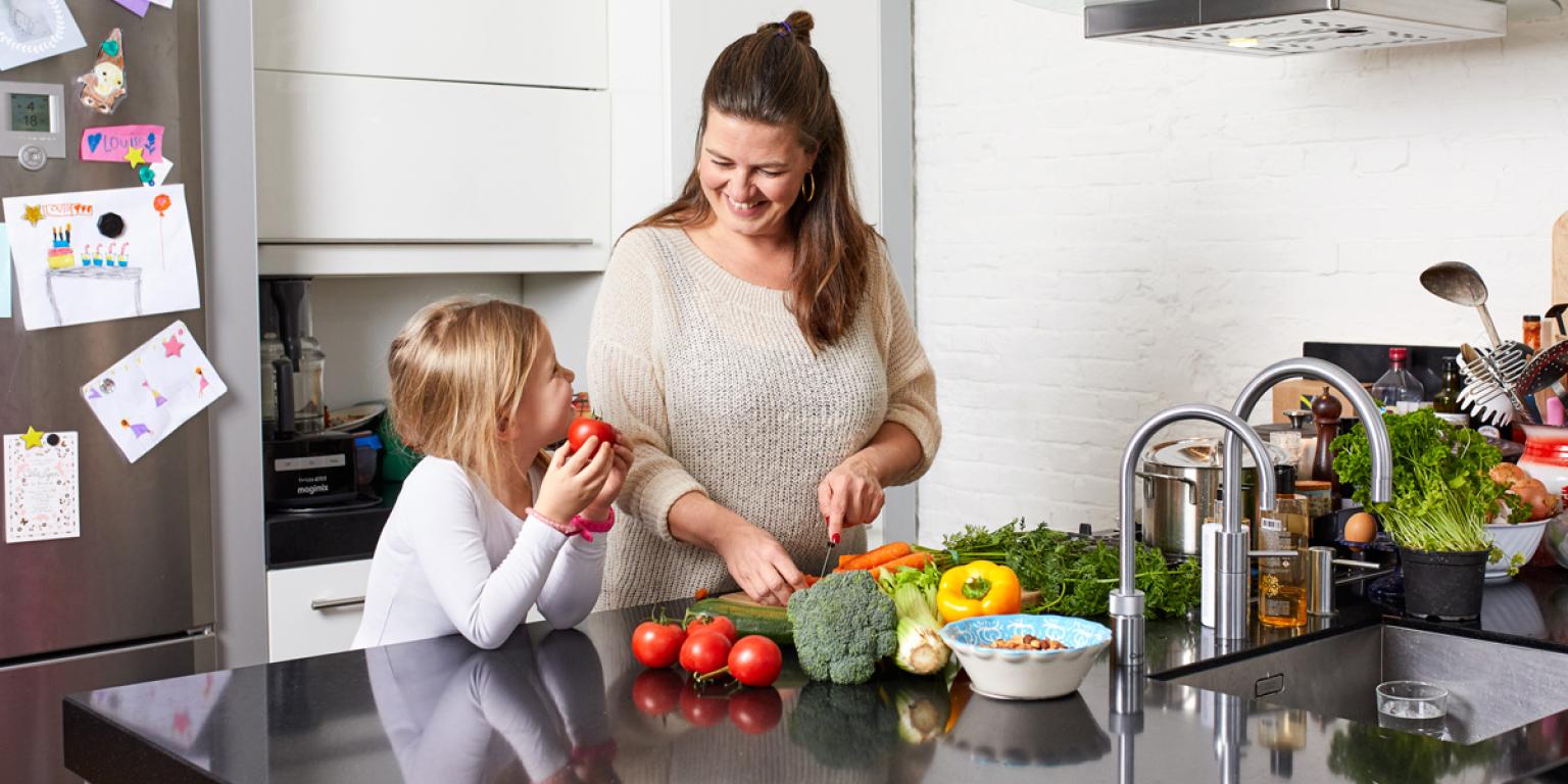 Vrouw in keuken vervangt suikerrijke voeding door gezonde groenten